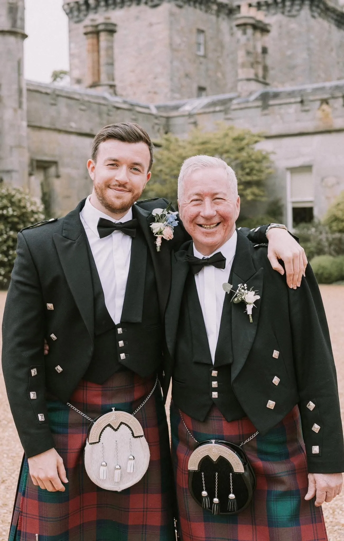 Steven and George Lindsay in kilts outside a Scottish castle