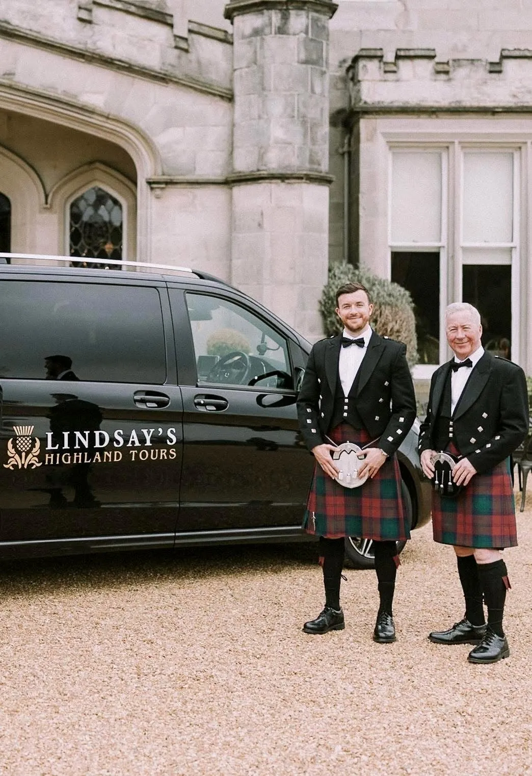 Steven and George Lindsay in kilts beside their Mercedes V-Class outside a Scottish castle