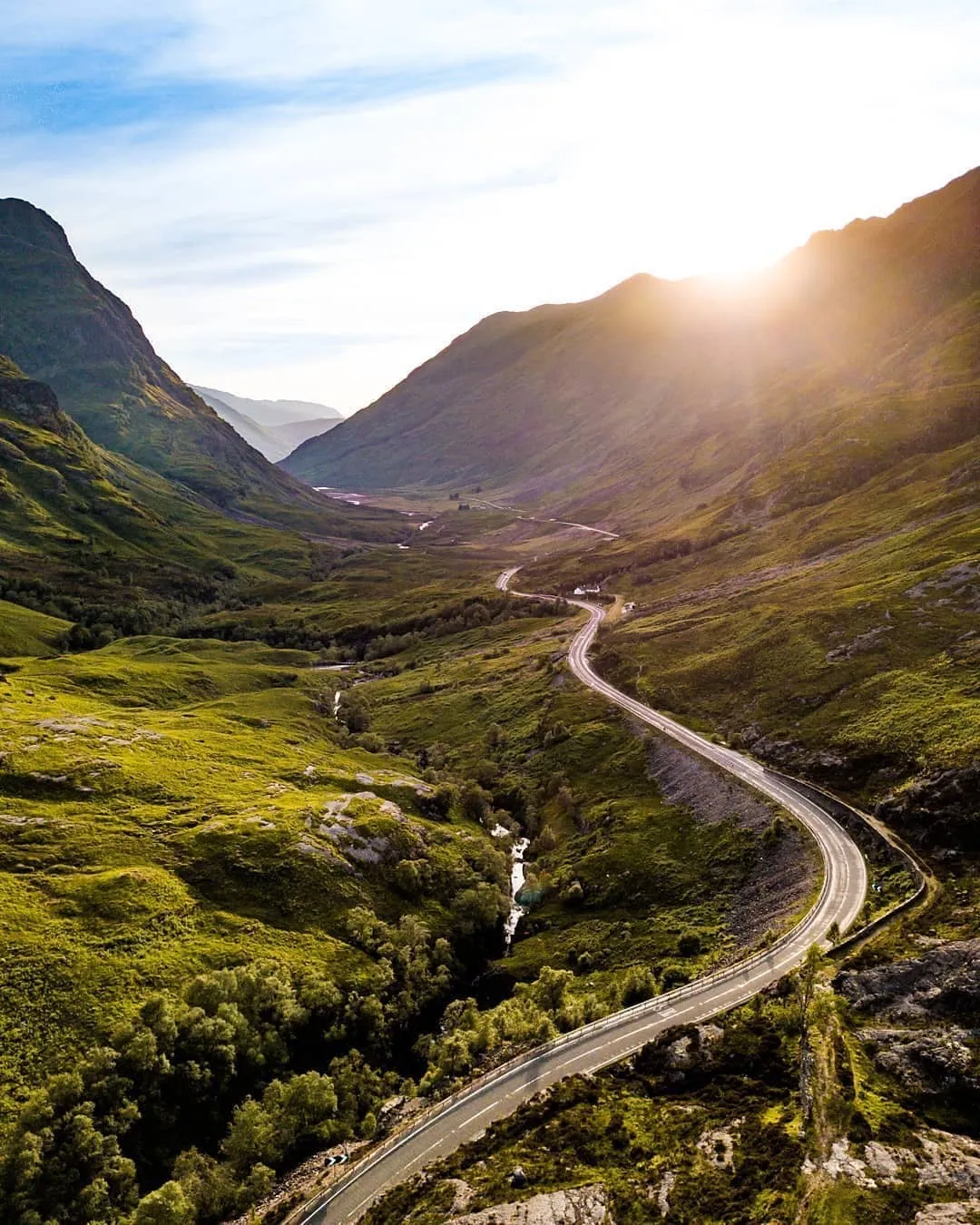 The road winding through Glencoe in evening sunlight