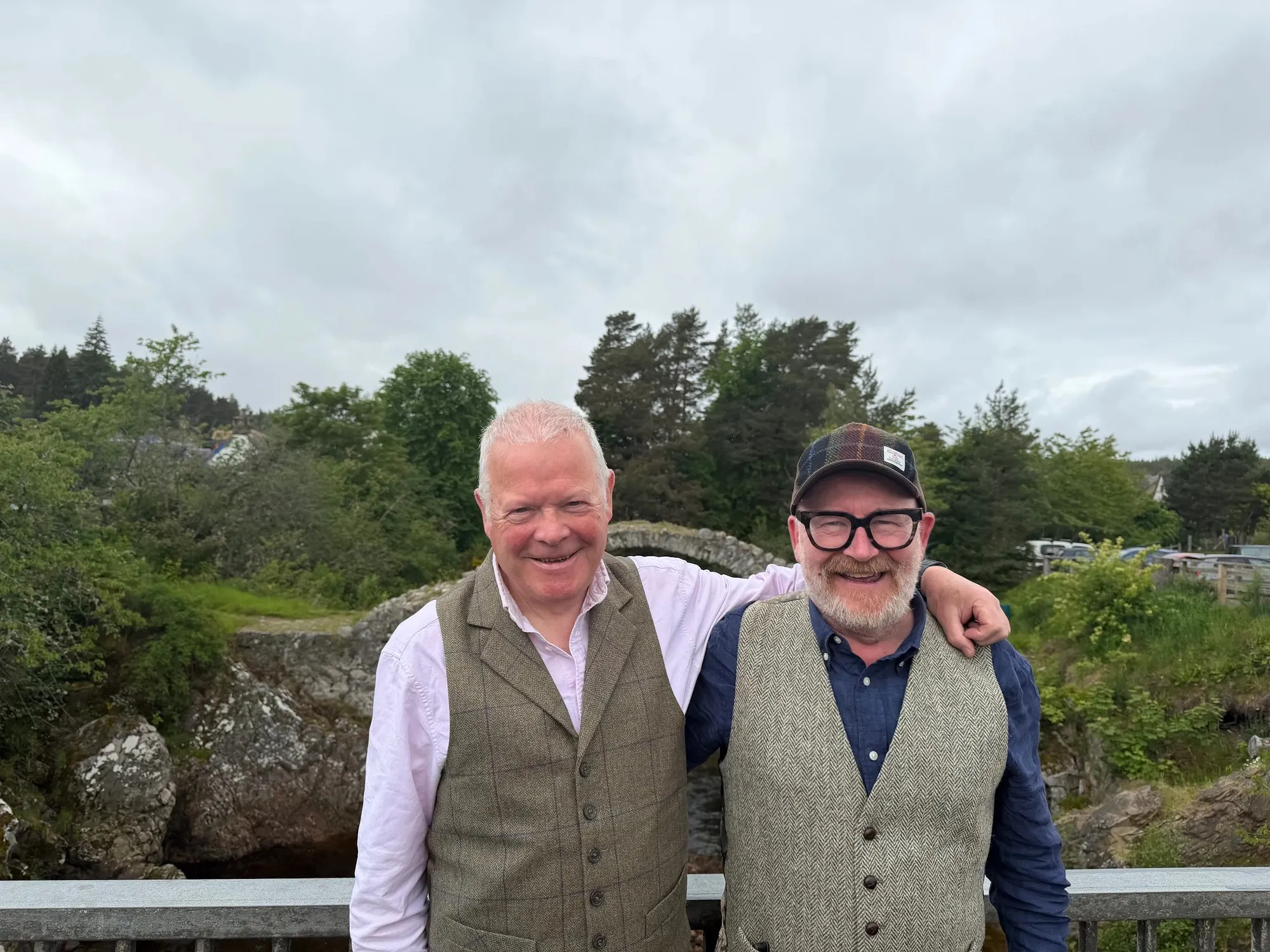 One of our guides with a guest beside an old packhorse bridge in the Highlands